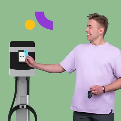 A young man paying at an EV charging station